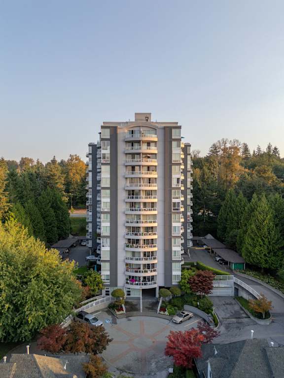 an aerial view of a tall building surrounded by trees