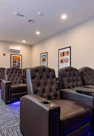 A row of brown leather recliner chairs are lined up in a row.