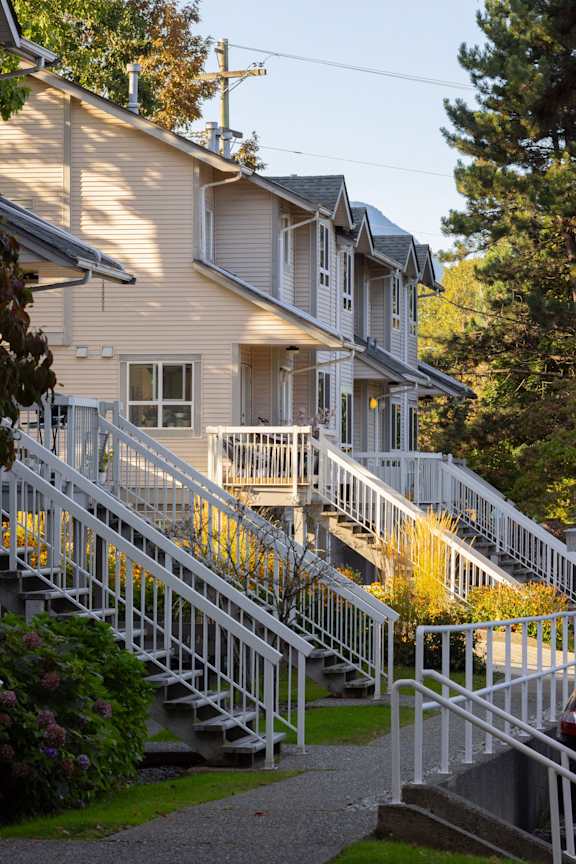 the front of a house with stairs and balconies