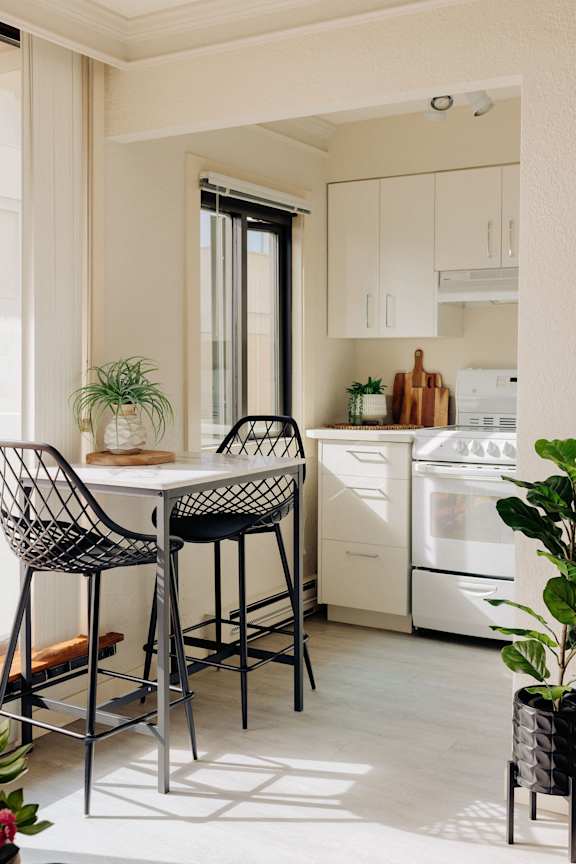 a kitchen with white appliances and a table and chairs