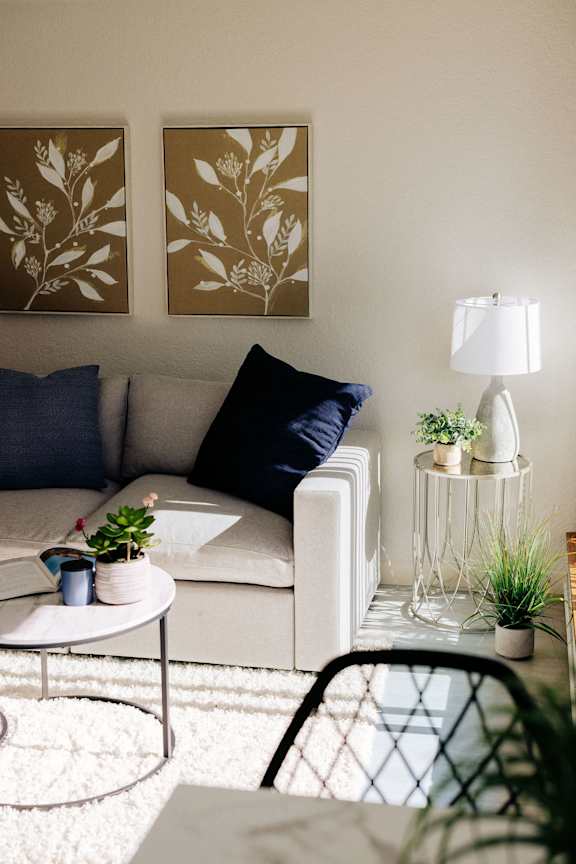 a living room with a couch and two paintings on the wall