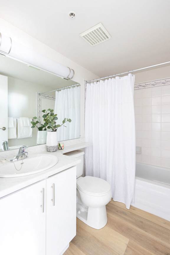 a white bathroom with a white toilet and a white shower curtain
