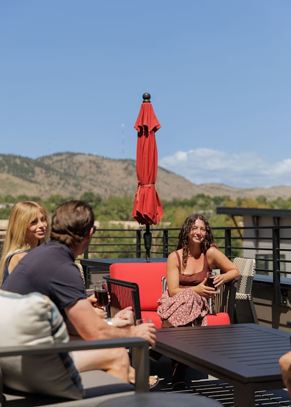 Four people toasting with drinks at a table.