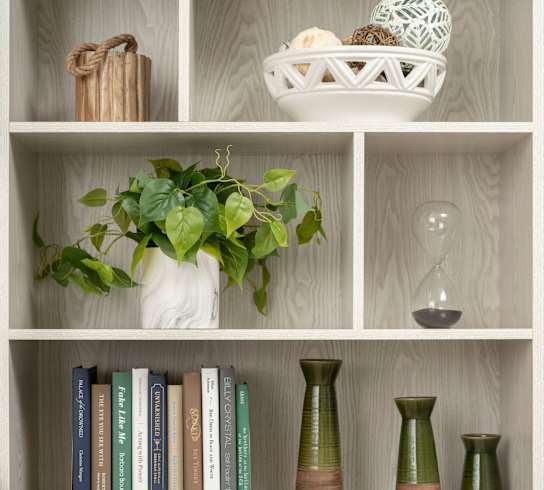 a bookcase with books and decorations on it