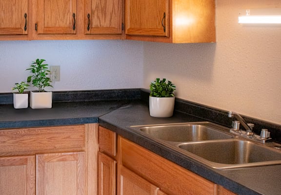 A kitchen with wooden cabinets and a checkered floor.