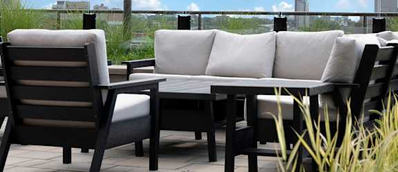 A patio with a table and chairs overlooking a city skyline.