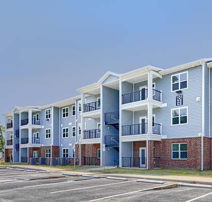 an empty parking lot in front of an apartment building