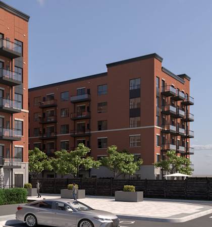 A modern apartment building with a car parked in front.