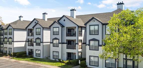 an exterior view of an apartment building with a parking lot