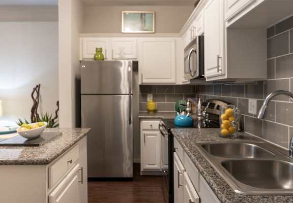 This is a photo of the kitchen in the 826 square foot 1 bedroom , 1 bath apartment at The Brownstones Townhome Apartments in Dallas, TX.