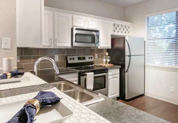 This is a photo of the kitchen of the 1661 square foot 3 bedroom, 3 and a half bath floor plan at The Brownstones Townhome Apartments in Dallas, TX.