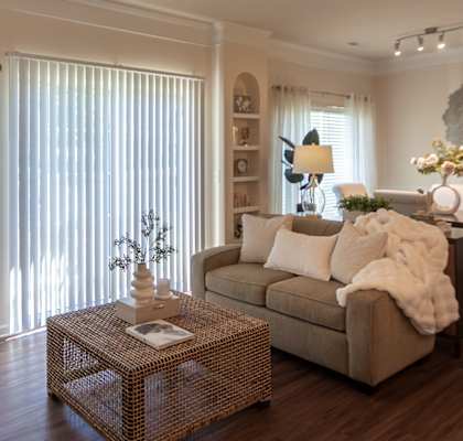 Entry hallway in the Islander 2-bedroom apartment at Nantucket Apartments in Loveland, Ohio, opening into a furnished living room with wood-style flooring.