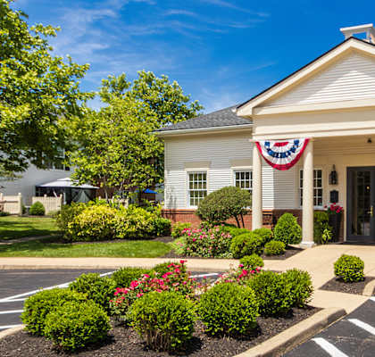 A white building with a red, white and blue banner on the front.
