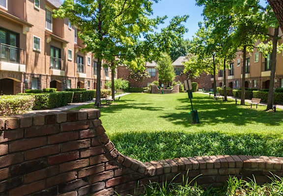 This is a photo of the building exteriors/the courtyard at The Brownstones Townhome Apartments in Dallas, TX.