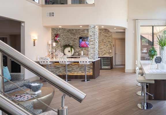 A modern living room with a stone accent wall and a staircase.