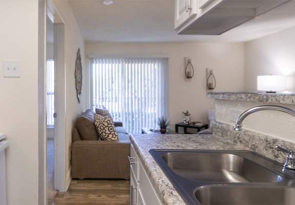 This is a photo of the living room from the kitchen of the 515 square foot 1 bedroom, 1 bath apartment at Canyon Creek Apartments in Dallas, TX