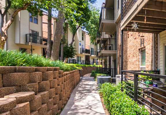 Walkway past some apartment patios at Canyon Creek Apartments in the Dallas Midtown neighborhood of Dallas, TX.
