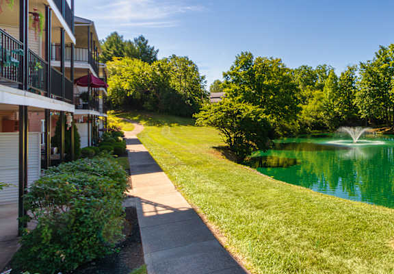 Private stocked fishing pond with fountain and landscaped walkway at Compton Lake Apartments