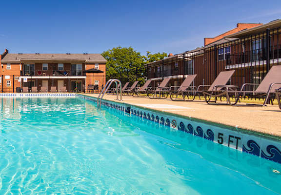 Sparkling pool with clear blue water and apartment buildings in the background