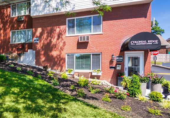 Corner view of the leasing office with manicured landscaping at Colonial Ridge Apartments in Cincinnati, Ohio