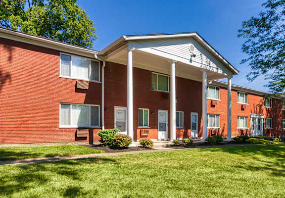 Courtyard view of brick apartment homes and shaded lawn at Colonial Ridge Apartments