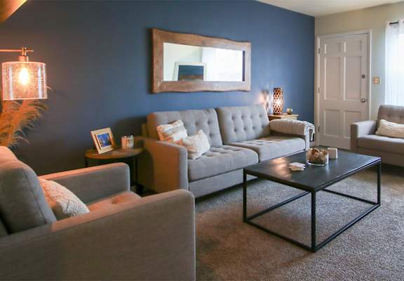 This is a photo of the living room room of the 550 square foot 1 bedroom, 1 bath, balcony floor plan model apartment at College Woods Apartments in Cincinnati, OH.