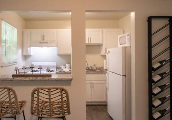 This is a photo of the kitchen with pass through breakfast bar of the 550 square foot 1 bedroom, 1 bath, balcony floor plan model apartment at College Woods Apartments in thne NOrth College Hill neighborhood of Cincinnati, OH.