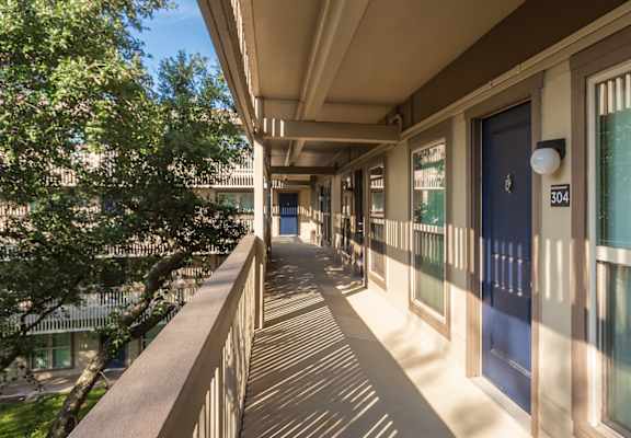 This is a photo of apartment entrances in the courtyard at Harvard Square Apartments, in the Vickery Meadow neighborhood of Dallas, TX.