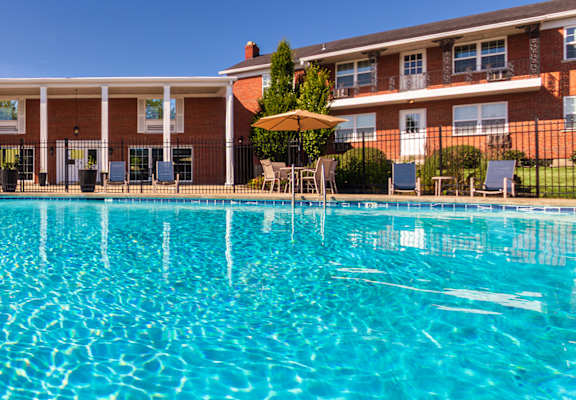 Wide view of the swimming pool and apartment buildings at Lake of the Woods Apartments