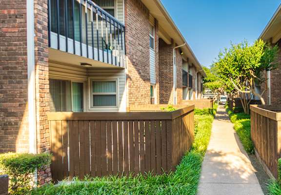 Apartment building exteriors showing patios, balconies and landscaping at Preston Park Apartments in the Far North Dallas neighborhood of Dallas, TX
