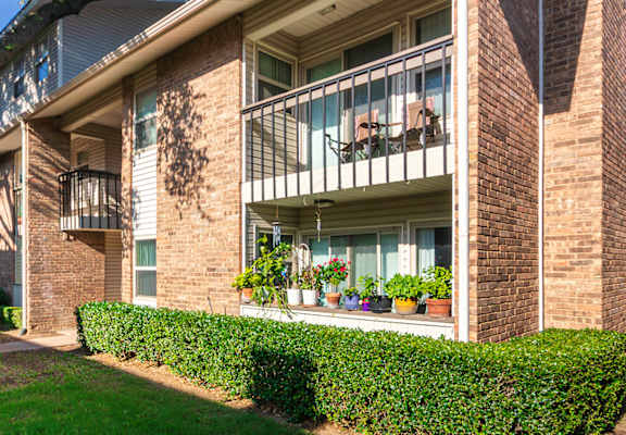 Apartment building exteriors showing patios, balconies and landscaping at Preston Park Apartments in the Far North Dallas neighborhood of Dallas, TX