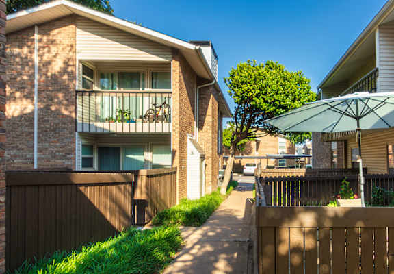 Apartment building exteriors showing patios, balconies and landscaping at Preston Park Apartments in the Far North Dallas neighborhood of Dallas, TX