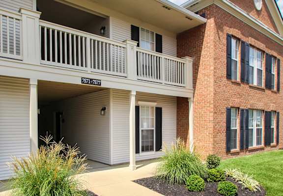 A red brick house with a white balcony.