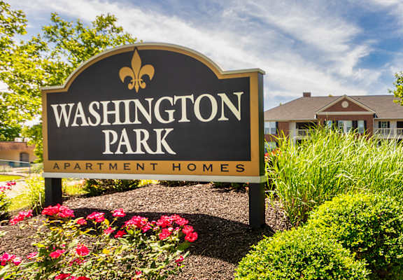 A sign for Washington Park Apartment Homes is in front of a building.
