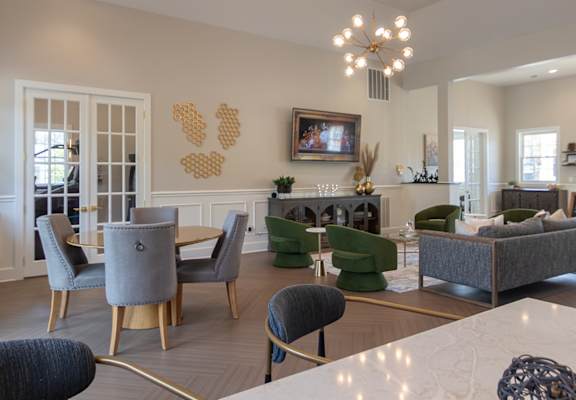 A large, well-lit living room with a dining area and a kitchen in the background.