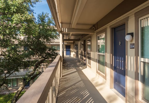 This is a photo of apartment entrances in the courtyard at Harvard Square Apartments, in the Vickery Meadow neighborhood of Dallas, TX.