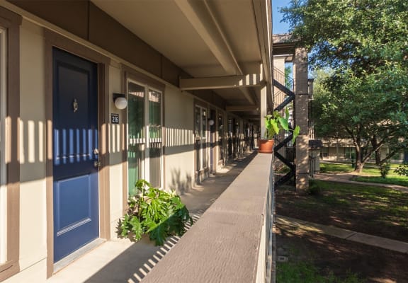 This is a photo of apartment entrances in the courtyard at Harvard Square Apartments, in the Vickery Meadow neighborhood of Dallas, TX.