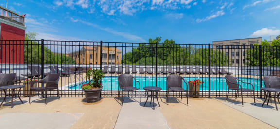 A pool surrounded by a black fence with chairs around it at The Argonne Apartments, Washington, DC, 20009