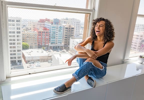 a woman sitting on a window sill