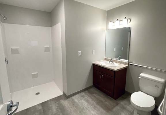 A bathroom with a toilet, sink, and shower.