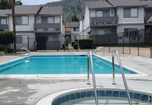a swimming pool with an apartment building in the background