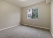 Thumbnail 10 of 17 - A room with a window and a view of trees outside.