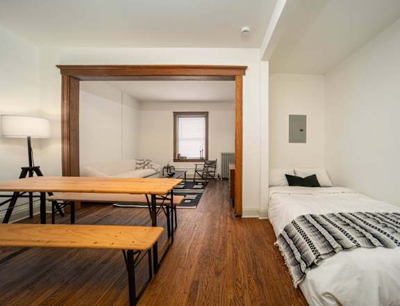 a bedroom with a bed and a desk and a living room