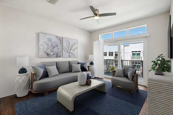 A living room with a grey couch, a white coffee table, and a ceiling fan.