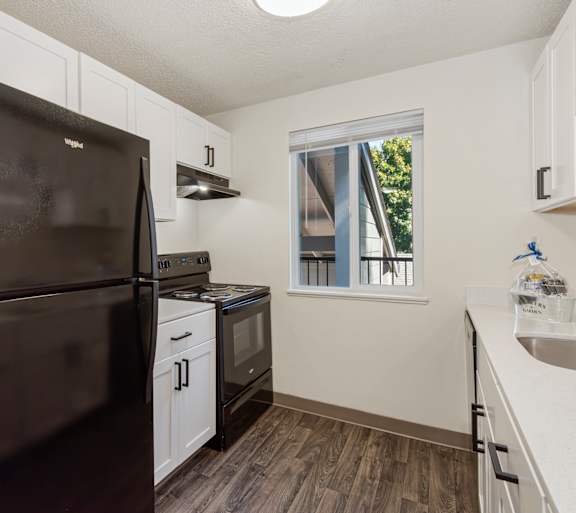 Kitchen with white appliances at Todd Village Apartments in Tualatin, Oregon