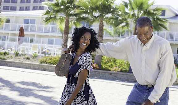 A man and a woman are walking together on a sunny day.