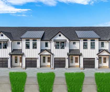 A row of white houses with black roofs and doors.