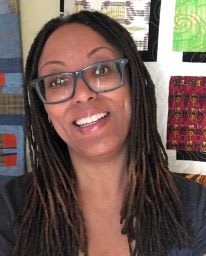 a woman wearing glasses and a black shirt