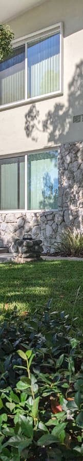 a yard with green grass and a building in the background