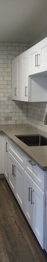 a kitchen with white cabinets and a sink